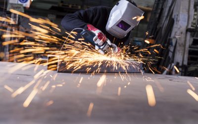 Metal industry worker grinding with mask on the face